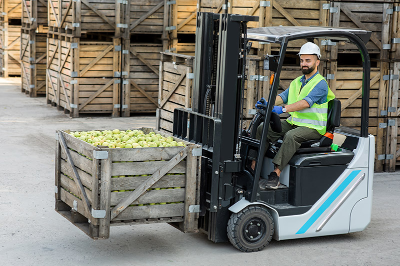 forklift driver with apples cargo